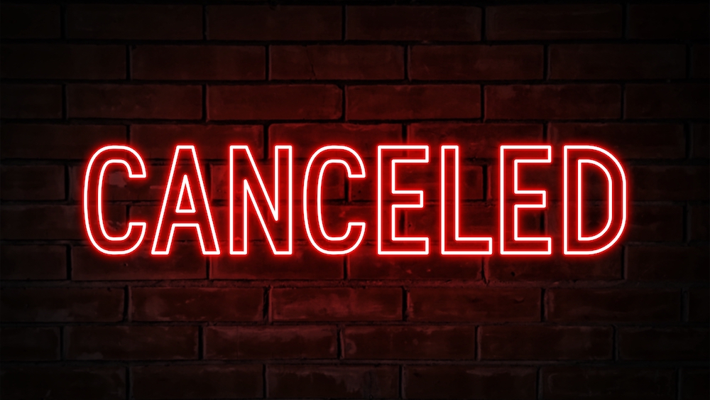canceled red neon light word on brick wall background