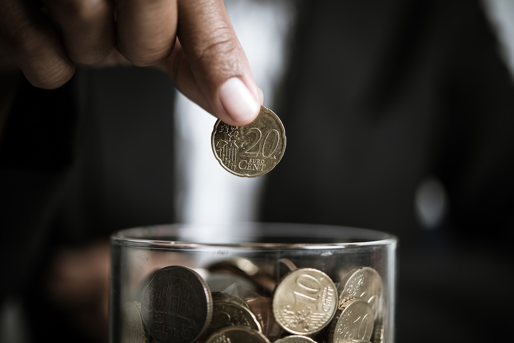 Person donating euros to charity as a path to wealth